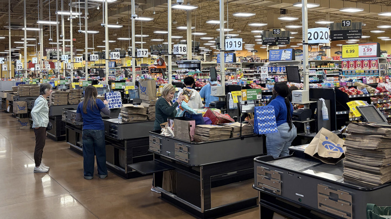 Customers and employees at the checkout of a Kroger grocery store.