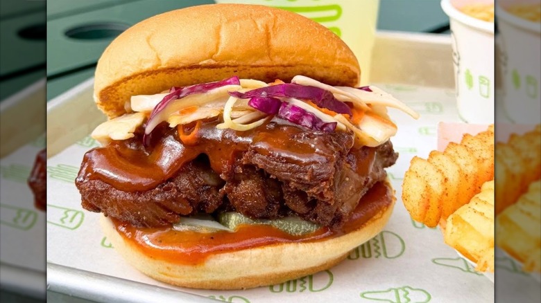 Shake Shack BBQ Boneless Baby Back Rib sandwich on paper-lined tray in restaurant.