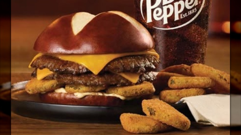 Double burger on pretzel bun with cheese and fried pickles.