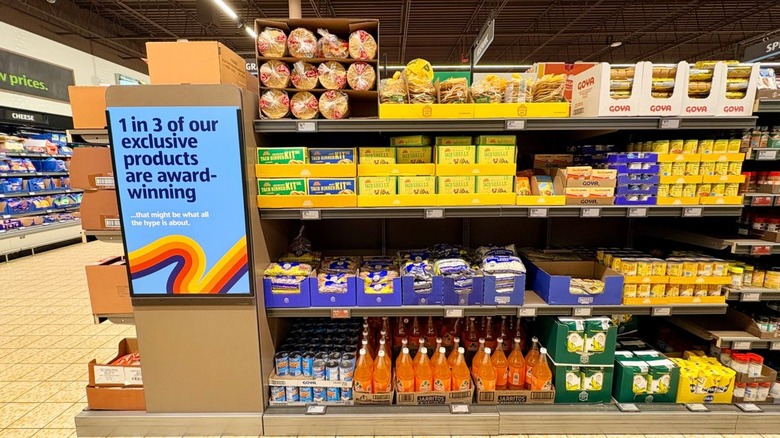 Shelves of products inside Aldi with signage on the left of the aisle boasting the store's award-winning items.