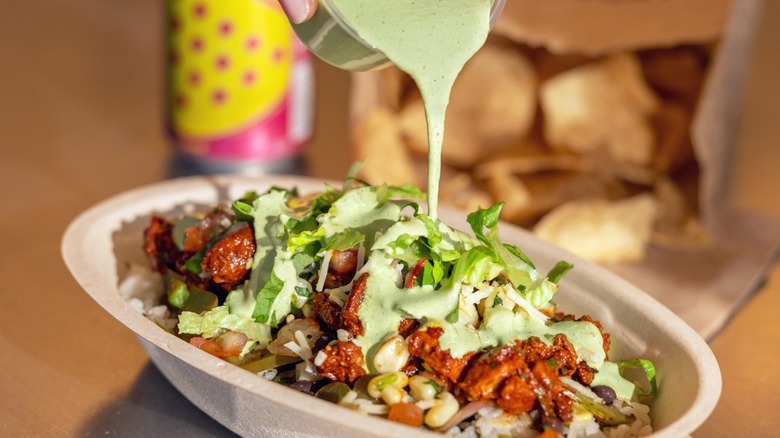 A Chipotle bowl with meat, vegetables, and the new cilantro lime sauce.