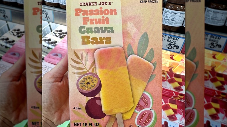 A hand holds up a box of Passion Fruit Guava Bars