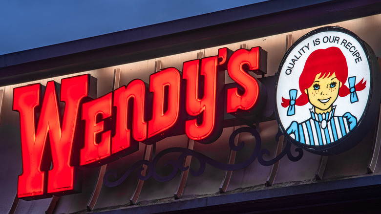Exterior of a Wendy's featuring its lit-up red lettering and logo.