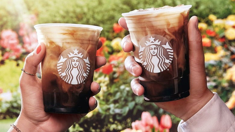 hands holding starbucks cups