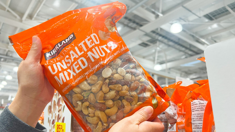 Kirkland Signature unsalted mixed nuts plastic bag being held up