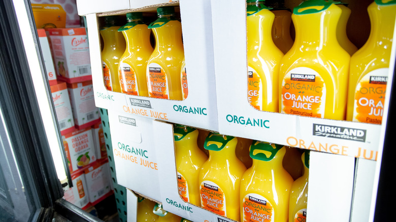 Kirkland Signature orange juice bottles stacked in a walk in freezer