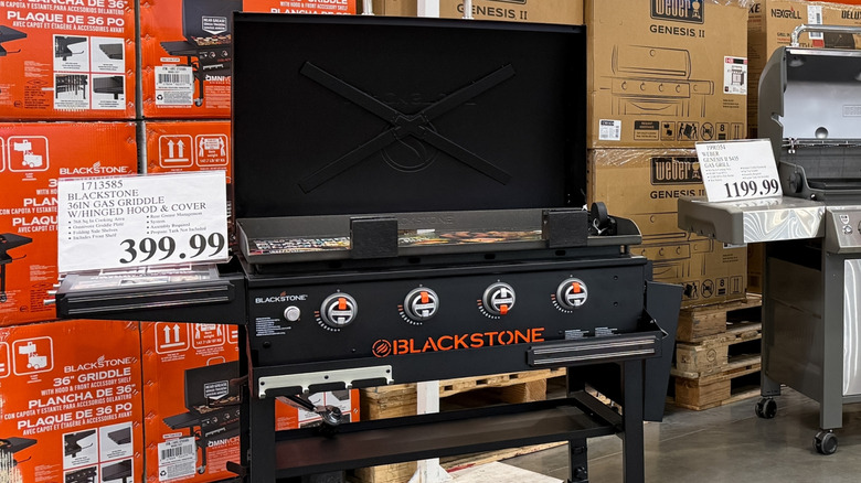 Blackstone logo on the front of an open flat-top griddle on display in store.