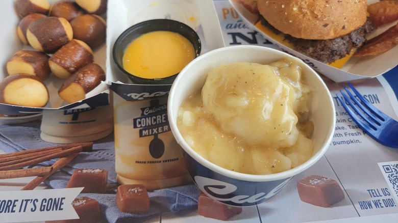 Cup of mashed potatoes with gravy on table