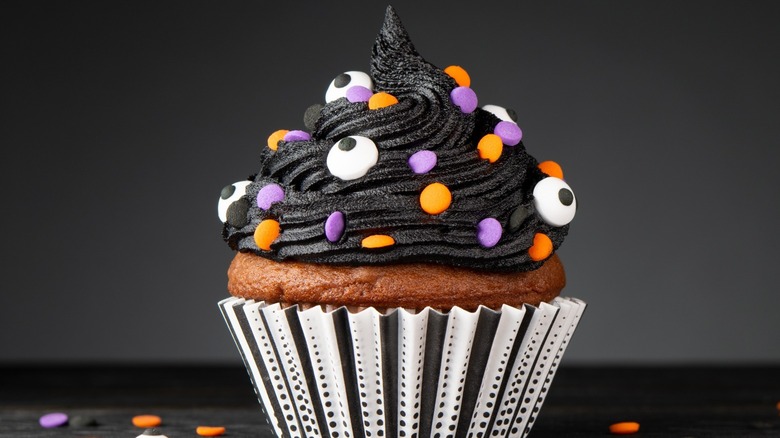 Black frosting and sprinkles on cupcake