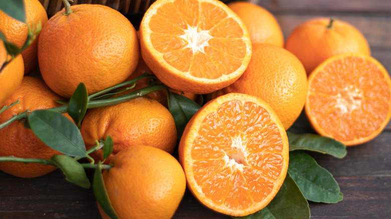 oranges sliced in half on a wooden board