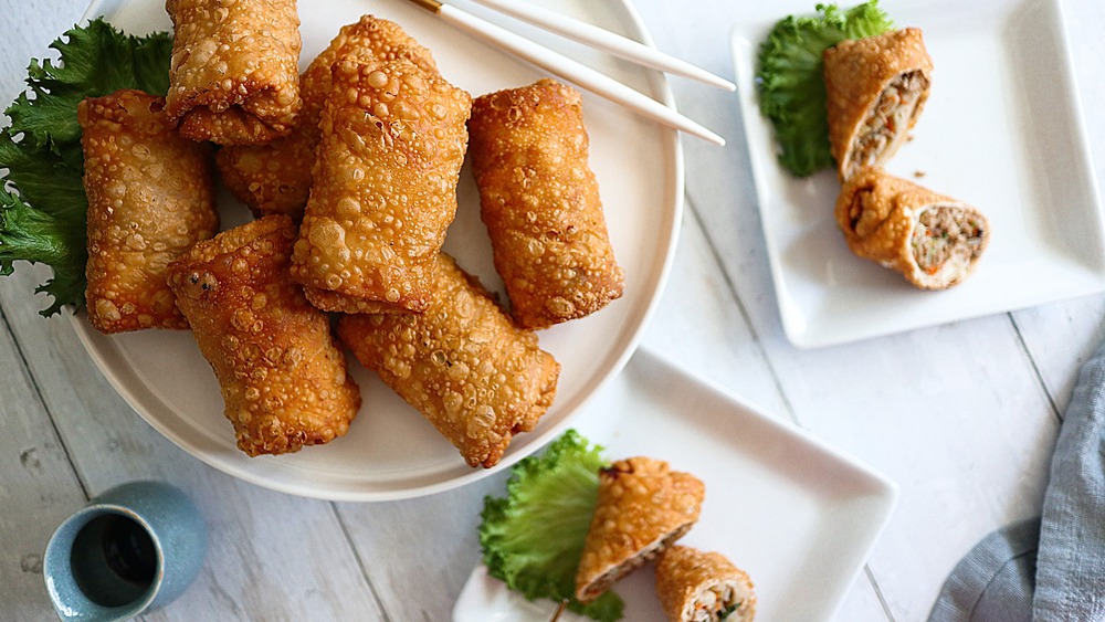 Egg rolls served on a platter and plates