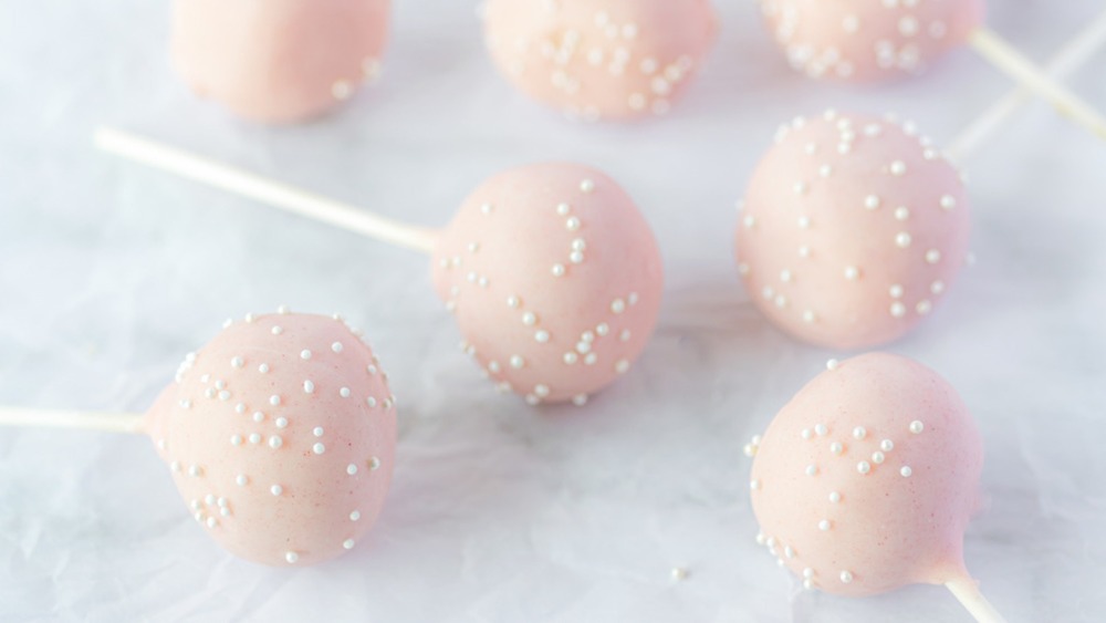 Pink cake pops on white surface