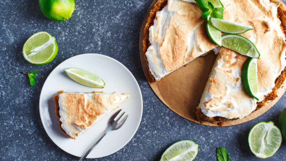 key lime pie slice on a plate with fresh limes