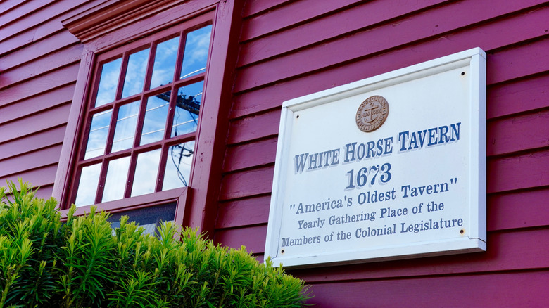Sign on red building indicating White Horse Tavern