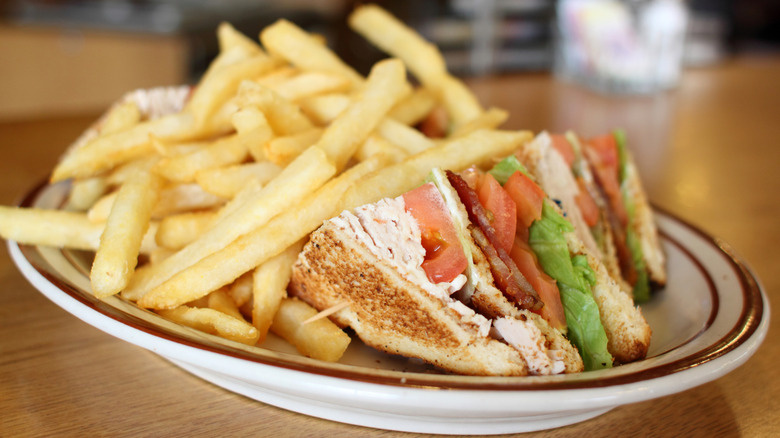 Classic dinner food, a club sandwich with French fries