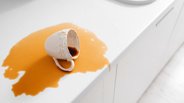 Spilled coffee cup on white countertop