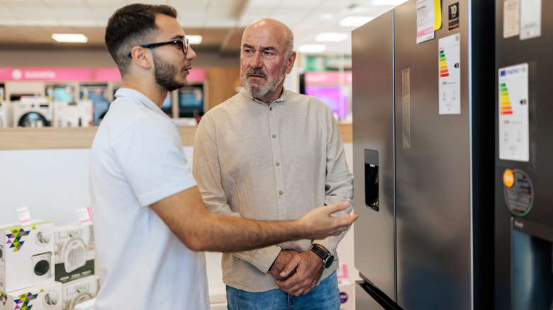 Two concerned customers shopping for a refrigerator