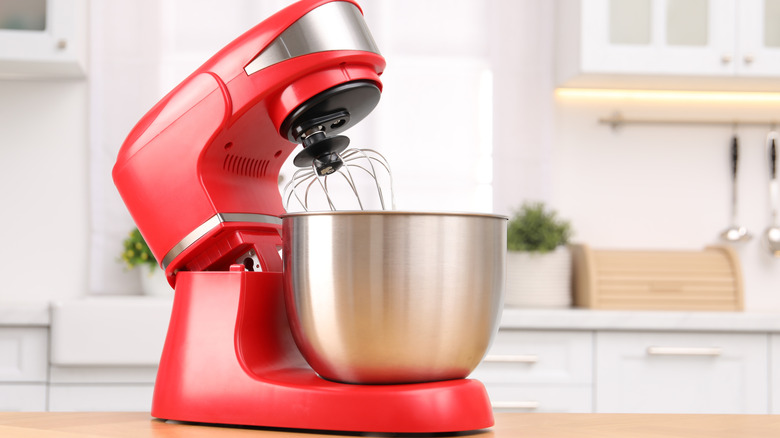 Red stand mixer on wooden table