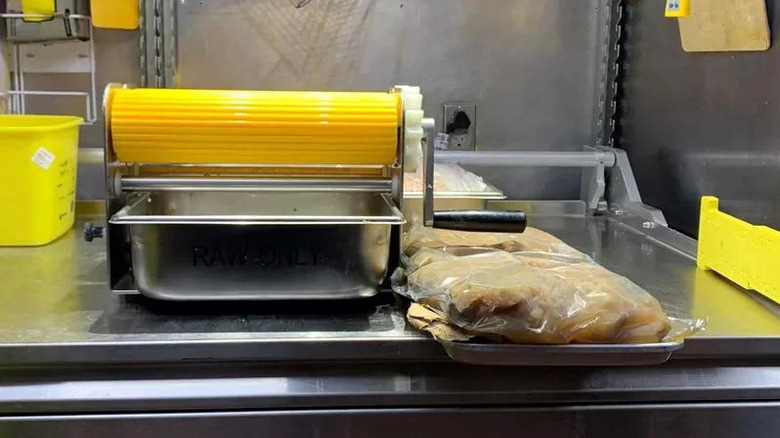 Industrial restaurant machine used to press raw chicken