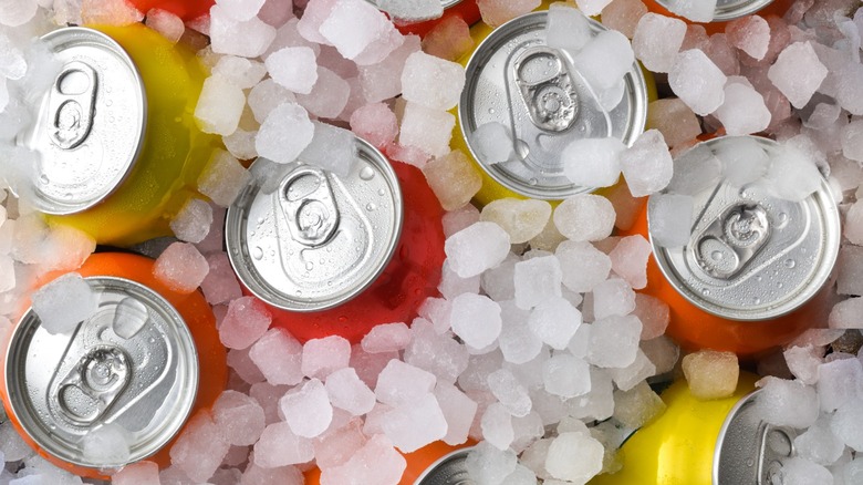 Tops of cans of soda in ice
