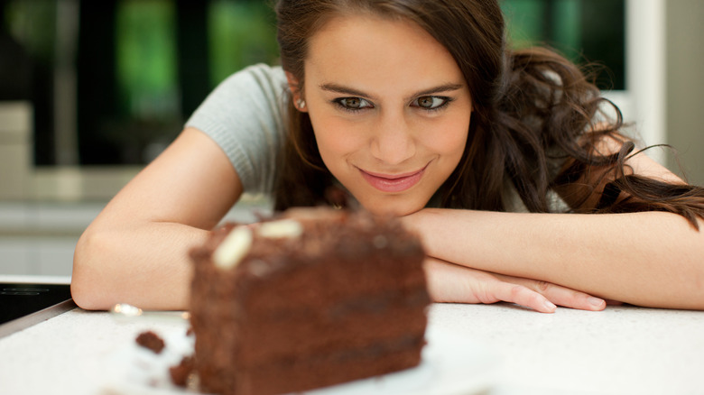 woman staring at chocolate cake