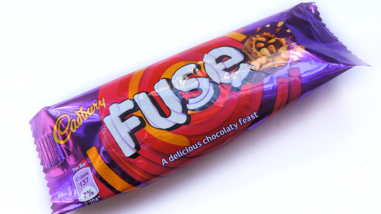 A Cadbury Fuse chocolate candy bar in a purple wrapper with red and orange swirl design
