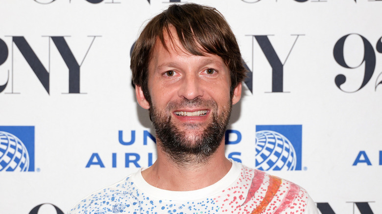 Restaurateur and chef René Redzepi smiling for cameras at publicity event.