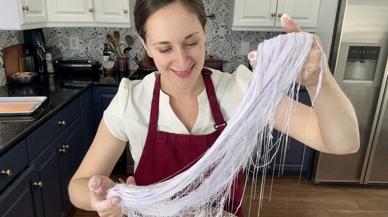 woman pulling dragon's beard candy