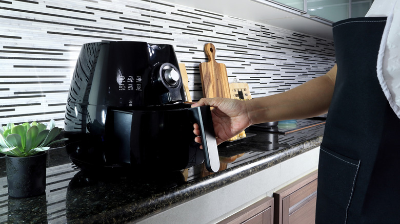 Person opening an air fryer