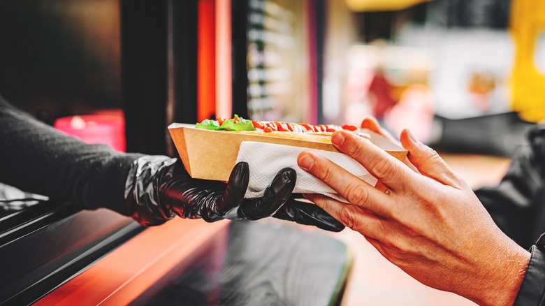 Employee hands off food to customer