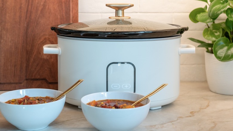 Slow cooker and two bowls of chili.