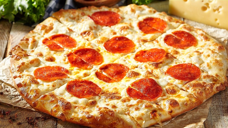 A pepperoni pizza on a wooden surface 