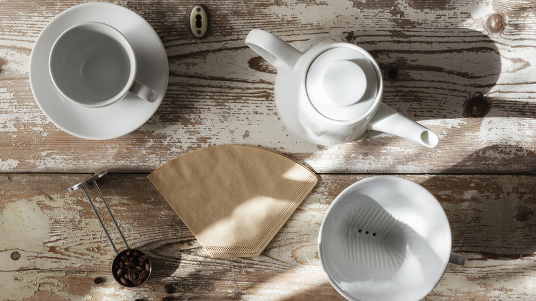 Coffee cup, kettle, and coffee filter on table