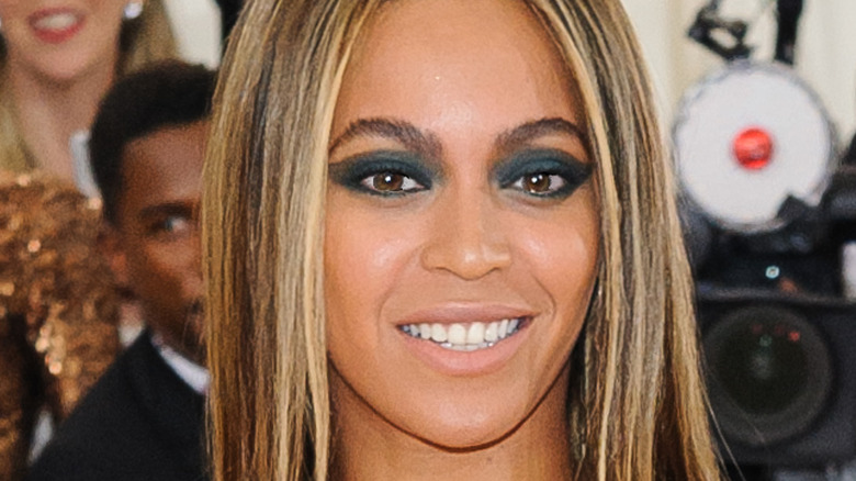 Beyoncé wears a beige dress with straight hair