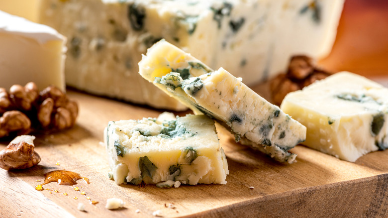 Sliced blue cheese on cutting board