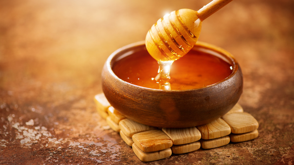 bowl of honey with wooden dipper