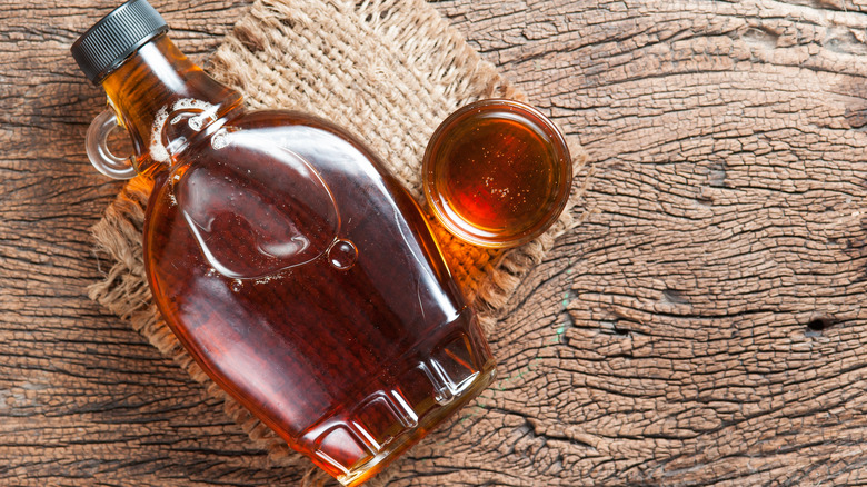 Bottle of maple syrup on a wooden board