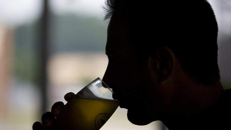 Sam Calagione tries a beer in silhouette
