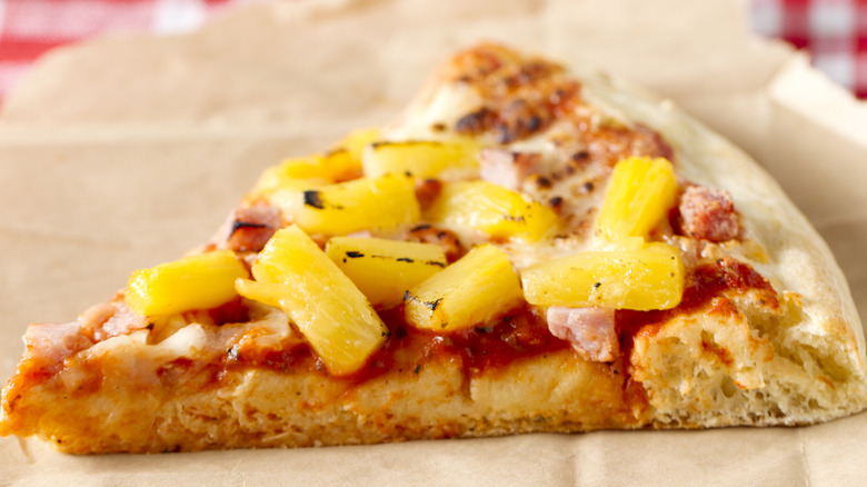 pineapple pizza slice on paper