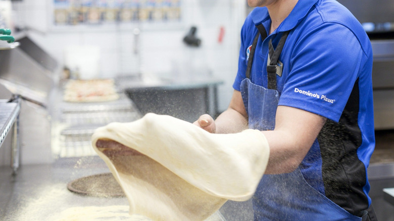 Domino's worker making pizza 