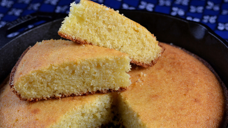 Closeup of sliced cornbread in a cast iron skillet.