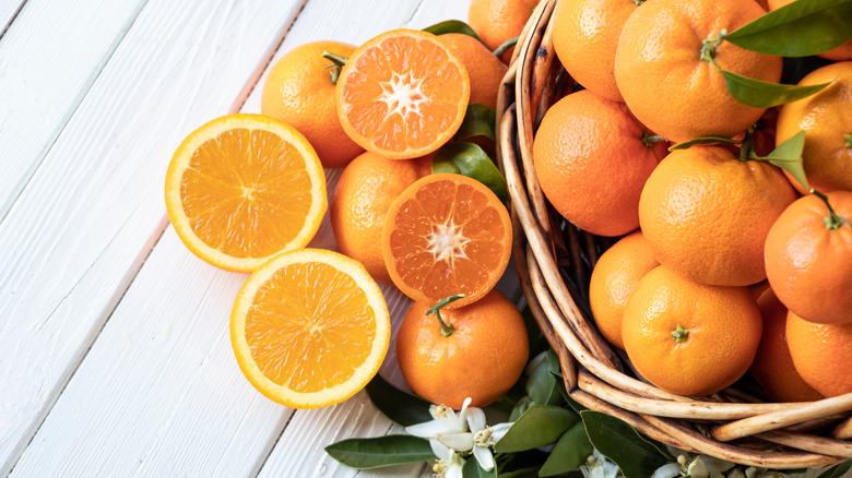 Basket of oranges with leaves and flowers