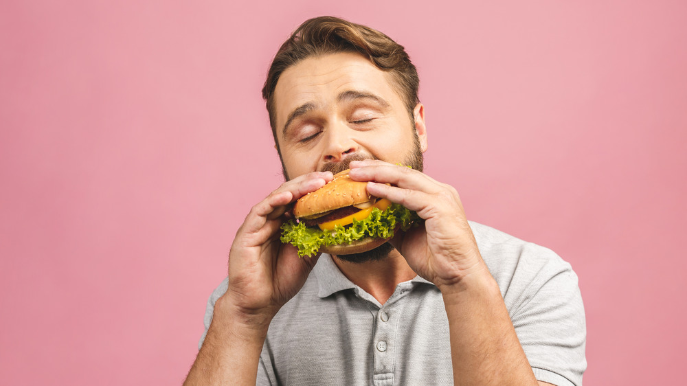 Man with beard eating a burger