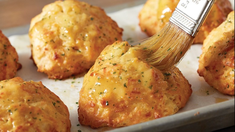 Cheddar biscuits being buttered