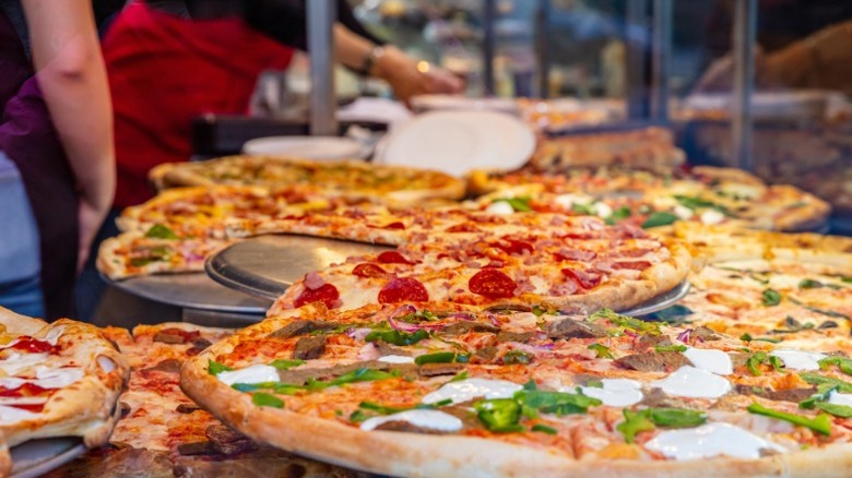 Assorted pizza pies in a display case