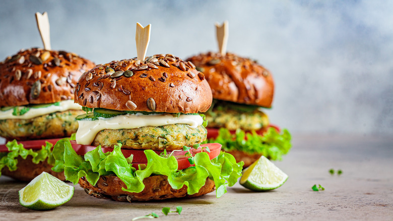 Three falafel burgers with lettuce, tomato, and aioli 