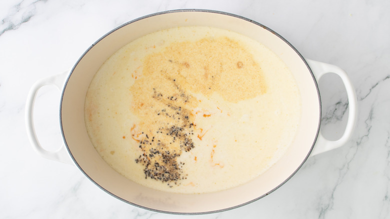 white liquid with black pepper in a white pot