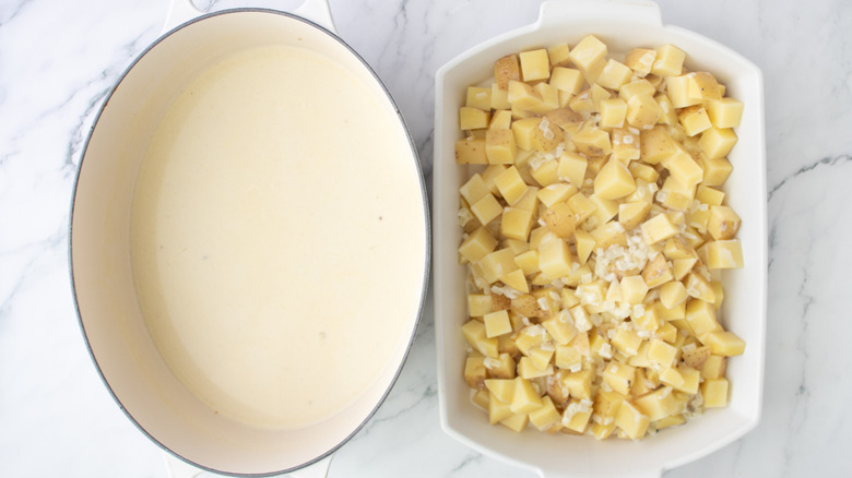 potatoes in a white pan next to a pot of white liquid