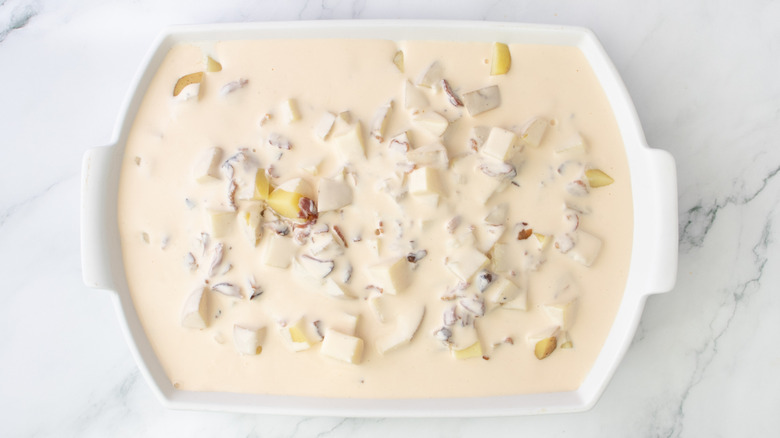 pale orange liquid and potato chunks in white pan