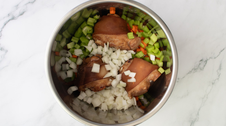 ham hocks and vegetables in a metal pot